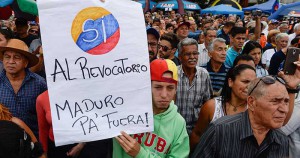 Anti-government demonstrators gather to sign the form to activate the referendum on cutting President Nicolas Maduro's term short, in Caracas on April 27, 2016. Opponents of Venezuelan President Nicolas Maduro hope to hold a referendum on removing him from office as early as November, a leading opposition figure said Wednesday. The center-right opposition has started gathering signatures to launch the first step towards a referendum to get rid of the socialist leader, whom they blame for an economic crisis and rising unrest.  / AFP PHOTO / FEDERICO PARRA